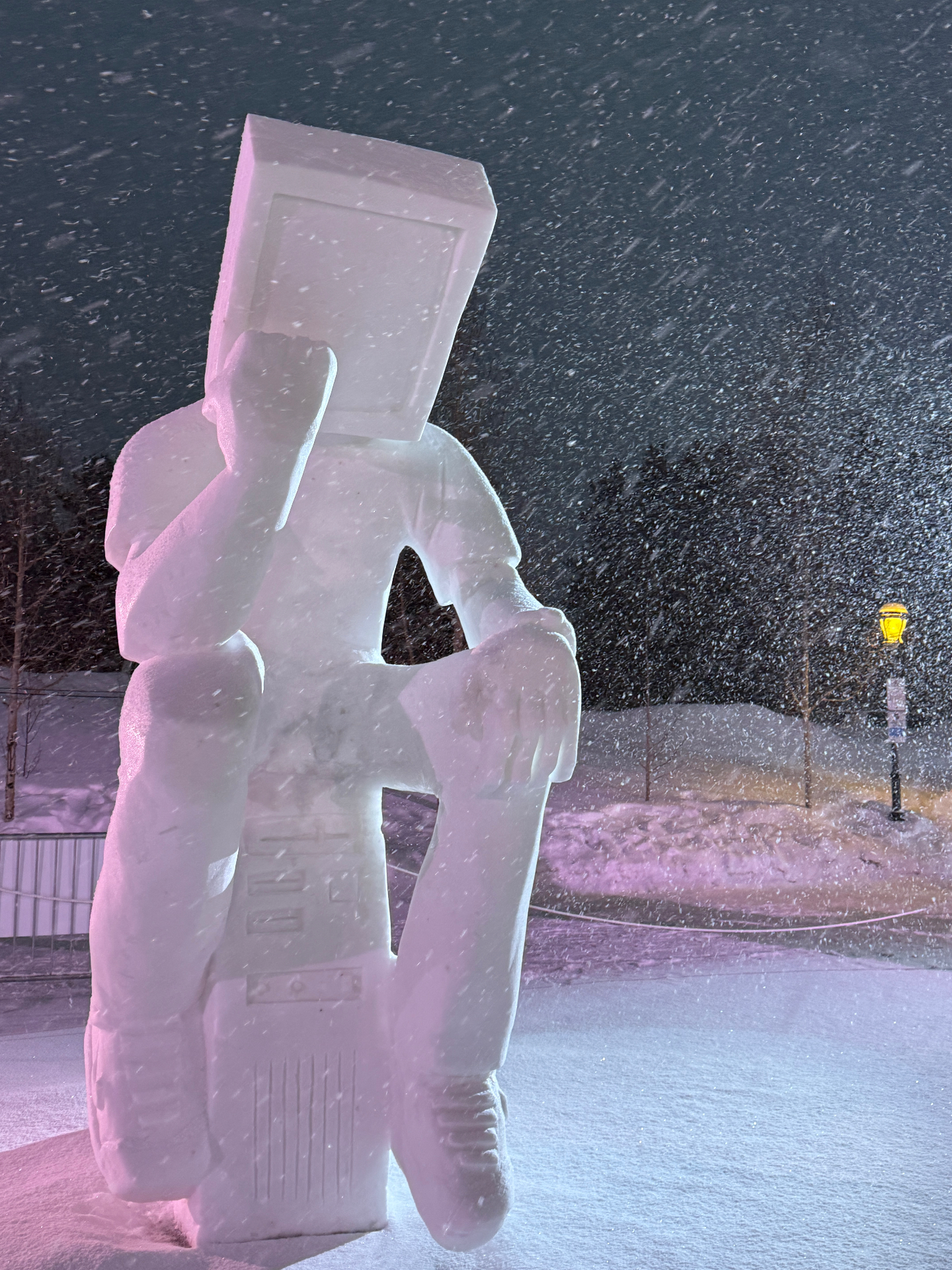 Snow sculpture seated in a storm, lit from within